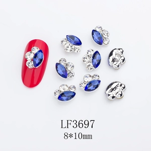 Macro shot of 8x10mm blue marquise nail rhinestones with alloy silver edge on red nails