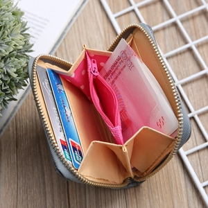Close-up of open mini fabric wallet showing pink polka dot coin pocket and card slots