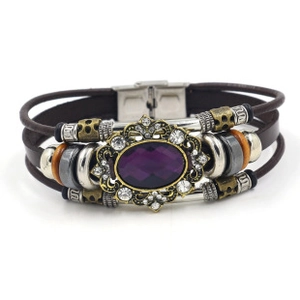 Close-up of bohemian leather bracelet with purple gemstone and vintage metal buckle