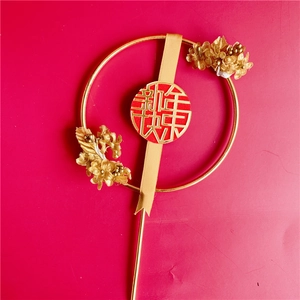 Detailed view of a golden acrylic cake topper featuring red berries and a festive ribbon