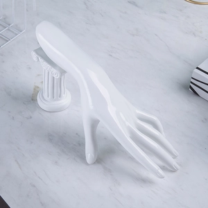 Polished white resin hand mold for jewelry display on marble surface backdrop