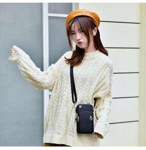 Détail d'un mini sac de téléphone noir avec double fermeture éclair sur un mannequin
