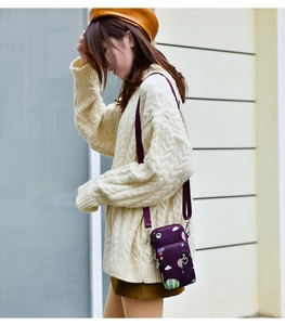 Détail de la pochette bandoulière en nylon violet imprimé avec motifs de montgolfières
