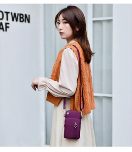 Détail du sac de téléphone en nylon violet avec plusieurs compartiments zippés et cœurs