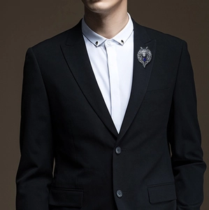 Detailed view of a vintage wolf head brooch with blue gems on a suit lapel