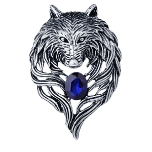 Vintage wolf head brooch in silver metal with a deep blue oval gemstone on white background