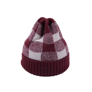 Detail of red and white checkered knit beanie featuring a thick ribbed cuff for winter