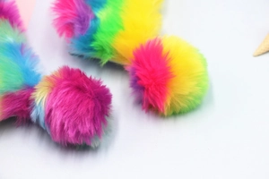 Macro di un astuccio in peluche arcobaleno che mostra la morbida trama della finta pelliccia