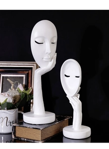 Close-up of modern white resin abstract face statues with textured matte finish details