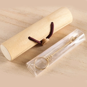 Golden rose cigarette ring holder with wooden storage case on wood background