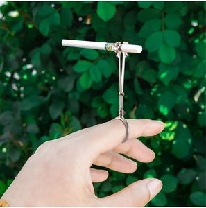 Close-up of rose flower cigarette holder ring worn on finger in an outdoor setting