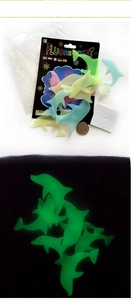 Luminous dolphin wall stickers with size reference coin and bright green glowing effect