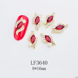 Detailed view of red marquise nail charms with gold metal base and white crystal accents