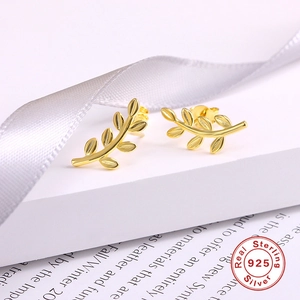 Detail of gold leaf earrings in 925 sterling silver on a white geometric stand