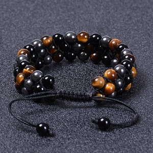 Three-layer braided bracelet with natural tiger eye and black onyx beads on dark background