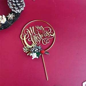 Detail of gold Merry Christmas cake topper with pine needles and red berries decor