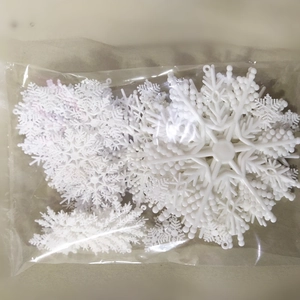 Detailed view of white plastic snowflake ornaments packed in a transparent plastic bag