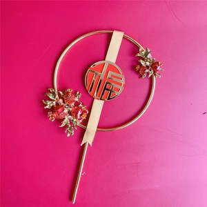 Close-up of golden metal wreath topper with red berries and Fu character detail
