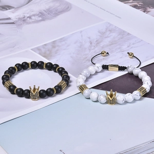 Macro view of white turquoise and matte black beads with gold crown cubic zirconia charm