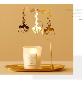 Close-up of golden reindeer carousel spinning over a frosted aromatherapy candle on a tray
