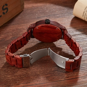 Macro detail of wooden watch back case with metallic folding clasp and redwood links