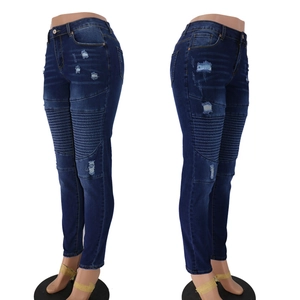Detailed side view of slim fit blue distressed jeans with moto ribbed knees and ripped denim