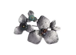 Detailed view of vintage silver floral brooch with dark natural stone inlays