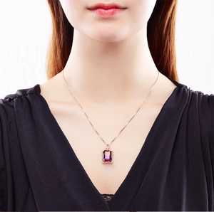 Close-up of rose gold necklace featuring a rectangular pink tourmaline pendant with small diamonds