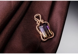 Macro shot of rose gold pendant featuring rectangle ametrine stone and small diamonds