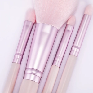 Makroaufnahme der 4-teiligen roségoldenen Make-up-Pinsel mit rosa Borsten und weißen Griffen