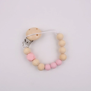 Detailed view of pink silicone and natural wooden beads on a secure baby pacifier clip