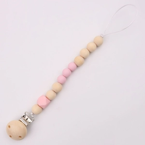 Detail of wooden and pink silicone pacifier clip with round beads on white background