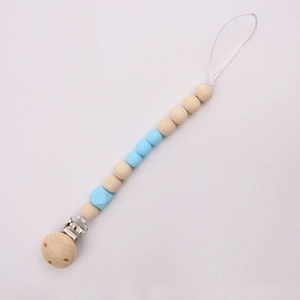Detail of wooden baby pacifier clip with blue silicone beads on a white background