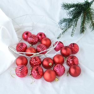 Red Christmas ball set with matte and glitter textures displayed in a metal basket