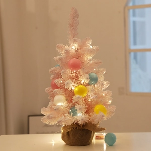 Pink desktop Christmas tree with LED lights and colorful ornaments on a burlap base