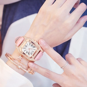 Detail of pink crocodile leather strap and rose gold crystal square watch on wrist