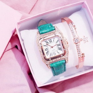 Close-up of elegant green leather square watch and gold star bracelet in a gift box