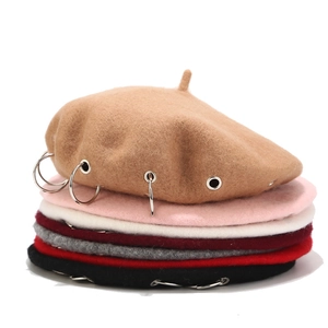 Detailed close-up of wool berets with punk style metal rings in various colors