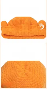 Detail of orange double-layered knit beanie with wavy folded brim and soft texture