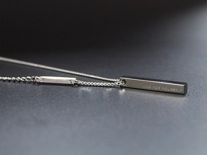 Macro shot of silver titanium pendant necklace engraved with Live For Yourself