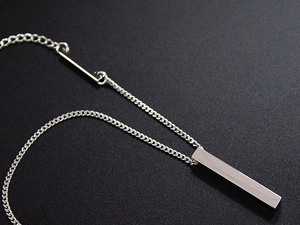 Macro shot of silver stainless steel vertical bar pendant with unique lobster clasp detail