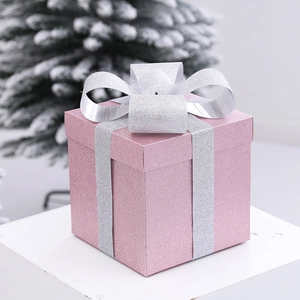 Pink frosted glitter gift box with silver ribbon on stand for Christmas window decoration