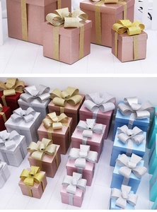 Detailed view of festive glitter gift boxes with silk bows in various sizes and colors