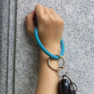 Sky blue silicone wristlet keychain with gold metal ring clasp shown on wrist