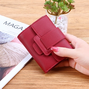 Compact red synthetic leather tri-fold wallet for women with snap closure held by hand