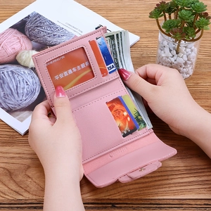 Pink minimalist trifold wallet for women featuring multiple card slots and a clear ID window
