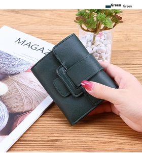 Close-up of green tri-fold PU leather wallet with litchi texture and buckle strap