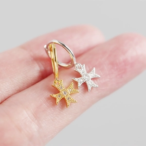 Macro view of S925 silver cross earrings with zircons shown on a finger for detail