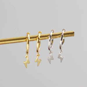 Makro-Detail von Blitz-Ohrhängern in Gold und Silber mit polierter Oberfläche