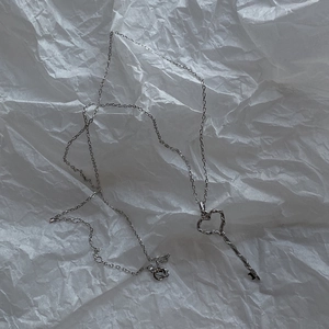 Detail view of 925 silver heart key pendant with textured twist design on a minimalist chain